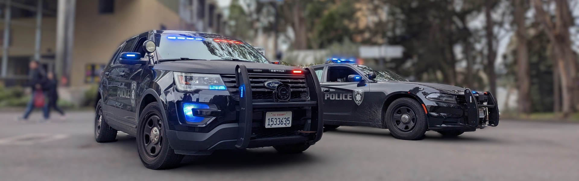 Image of UPD Police SUV and vehicle parked near Student Services Building