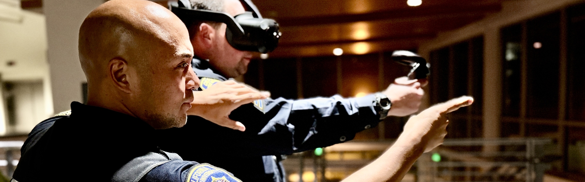 Image of a police officer training a second police officer in the use of VR.